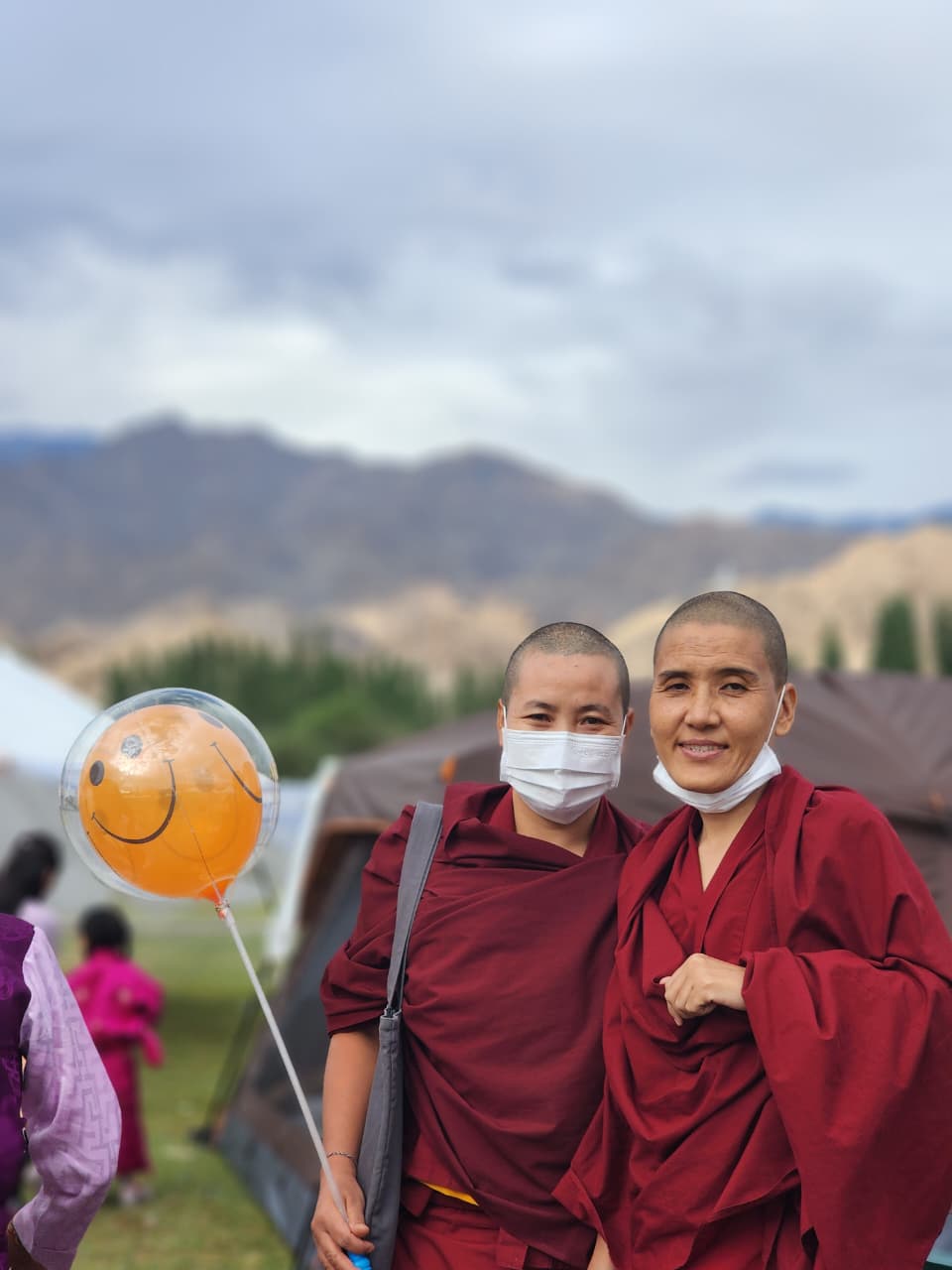 Two young monks smiling with a balloon at a festival